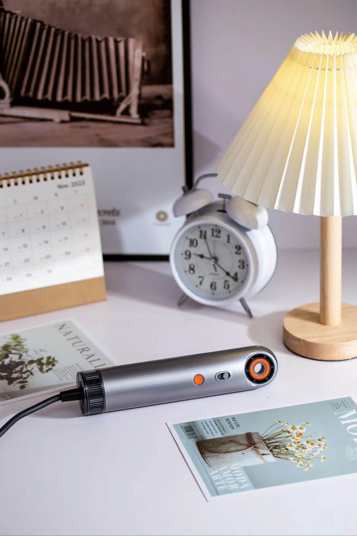 SYLPH 2 hair dryer on a desk workspace with a lamp and notebooks