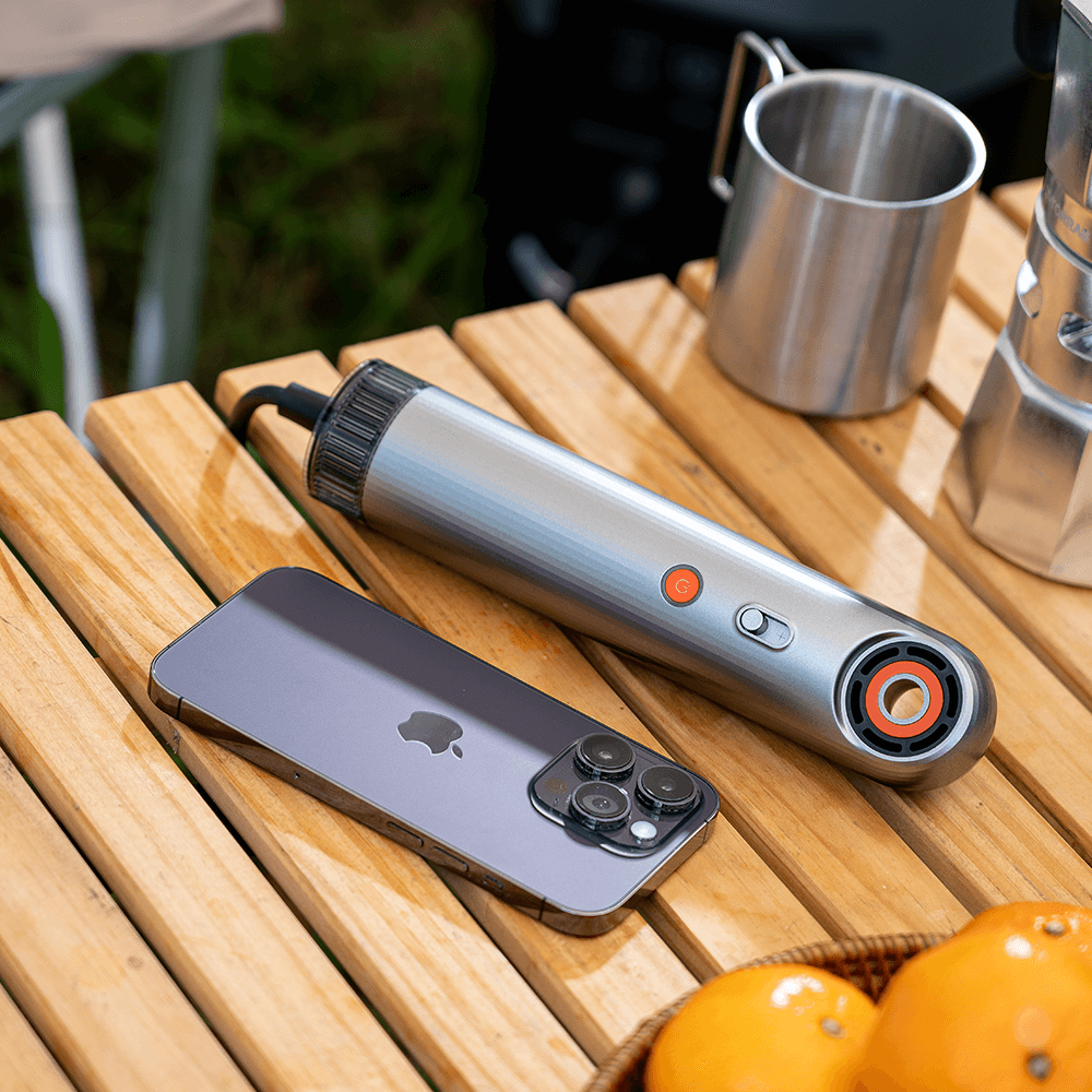 SYLPH 2 hair dryer flat lay on a wooden table with a smartphone and oranges